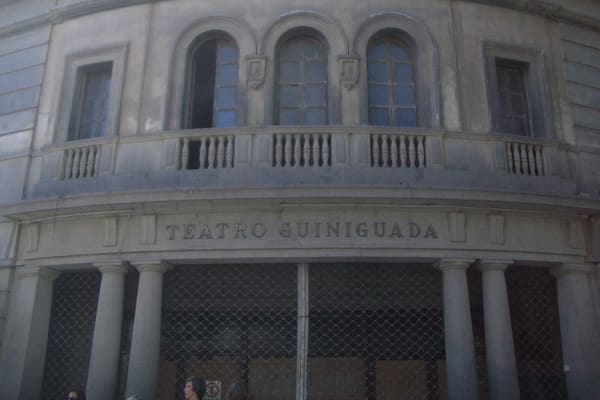 Fachada curva del Teatro Guiniguada con su nombre grabado sobre la entrada porticada